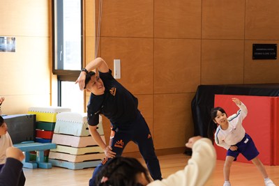 備運動をする松村先生と園児たち