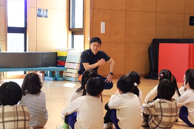 子どもたちに話しかける体育専任講師の松村先生