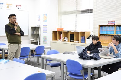 数学の授業で先生と会話するYuuさんと友人