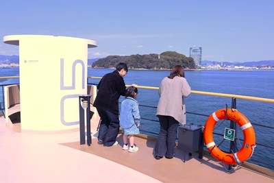 フェリーから海を眺める家族