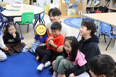 ShunichiさんとYuuさんの膝の上に座る幼児クラスの生徒たち