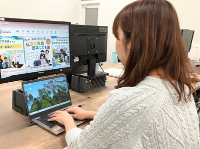パソコンを開いて仕事をする様子のFさん