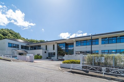 青空と山が背景の広島インターナショナルスクール校舎の外観