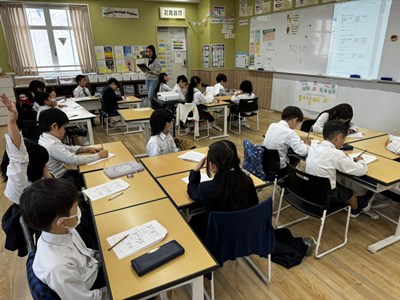 机に向かって学習する大勢の児童