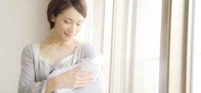 赤ちゃんを抱いて見つめる母親