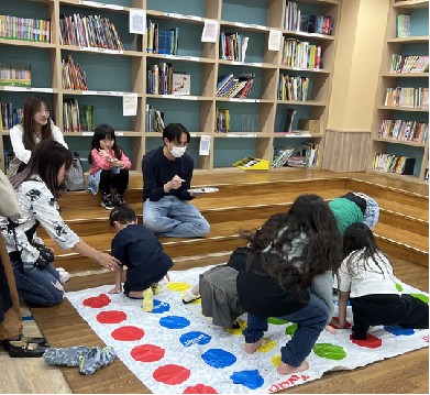 ツイスターゲームを楽しむ保護者と児童