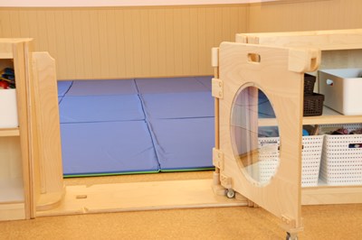 丸い窓の扉の後ろには青いマットが敷かれたフロア