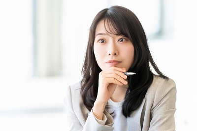 あごに手を添えて考える女性