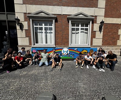 校舎前の絵画の前で集合する先生