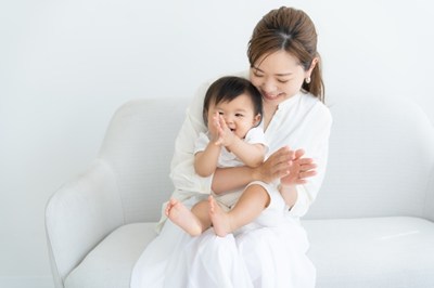 赤ちゃんを膝に抱えたお母さん