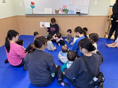 読み聞かせをする保育士と園児