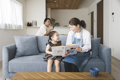 ソファで笑い合う母娘と見守る父