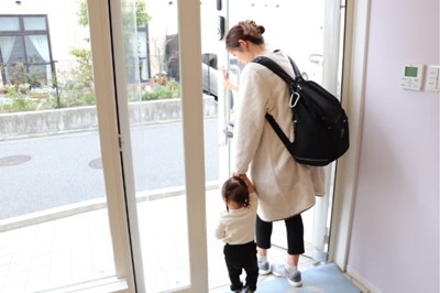 保育園から子どもの手をつないで帰宅するお母さん