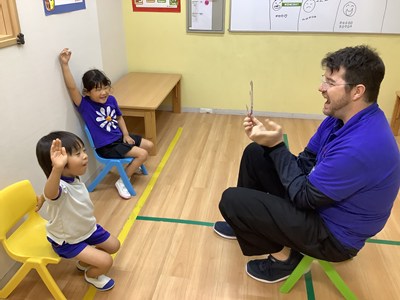外国人スタッフと挙手する子どもたち