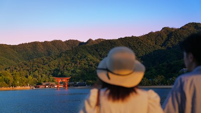 厳島神社の大鳥居を眺めるカップル