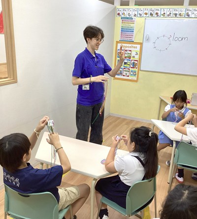 教室の前に立ち子どもたちに説明するスタッフ