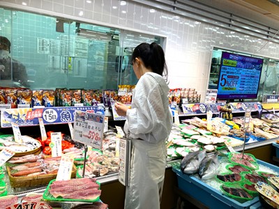 イオンスタイルの鮮魚コーナーで買い物する女性