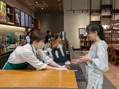 スターバックス コーヒーでドリンクを受け取る女性