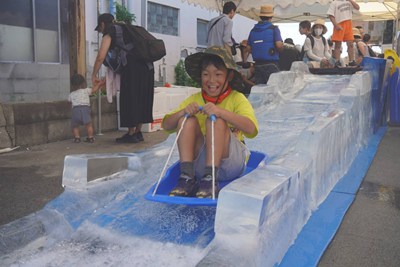 氷の上でソリ滑りをする男の子