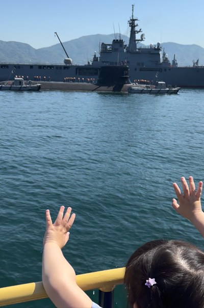 戦艦に向かって手を振る女の子