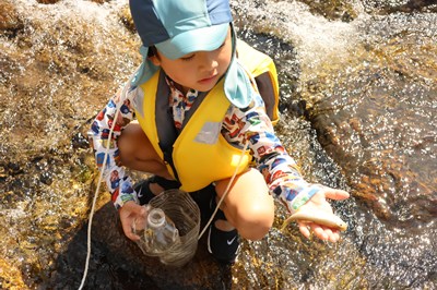 つかまえた魚を手にする子ども