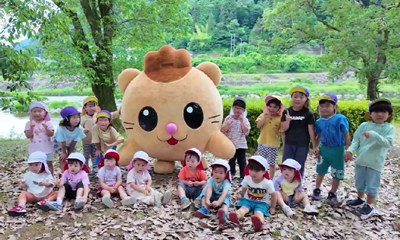 「もりみん山のこども園」のマスコットキャラ、もりみんと並ぶ子どもたち