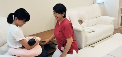 産後院で助産師に指導を受ける母子