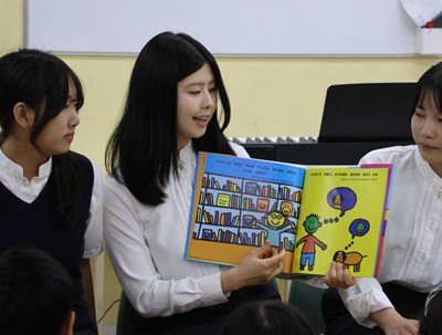 絵本を読み聞かせている女子高生