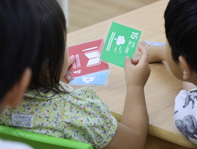 SDGs15番目のカードを手に持つ子ども