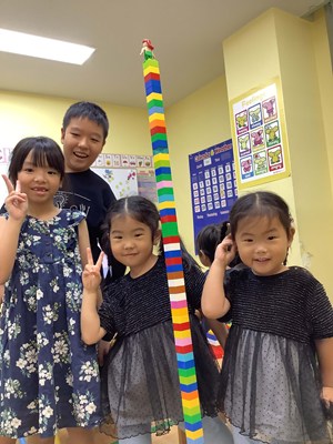 ブロックを積み上げて記念写真を撮る児童たち
