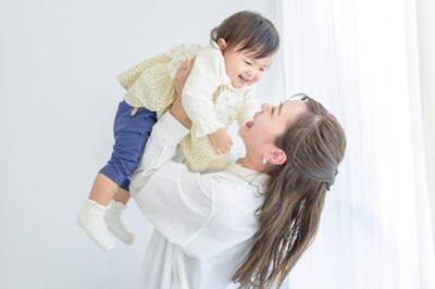 乳幼児の女の子を抱き上げる母親