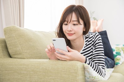 スマホを見ながら操作する女性の姿