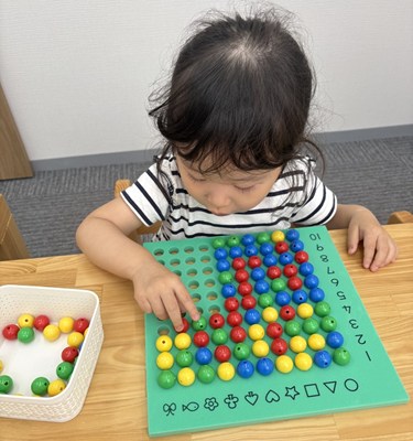 珠数えの教具で遊ぶ女の子