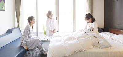入院中の母子と会話する女性